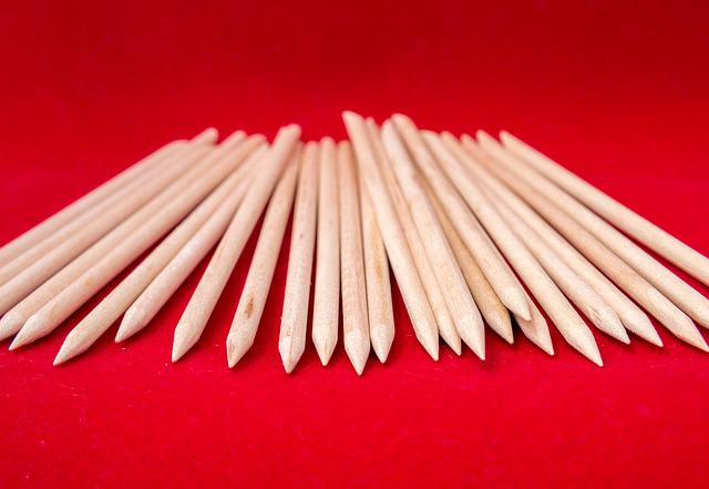 des cure-dents en bois sur une table avec un tapis rouge