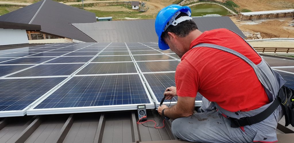 placement de panneaux solaires sur un toit par un technicien