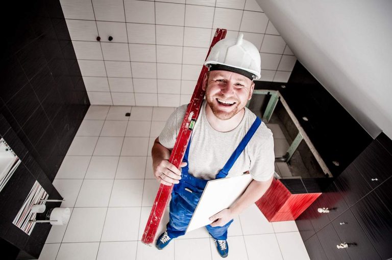 photo montrant un tableau et illustrant combien de m2 pose un carreleur par jour en fonction de la superficie - un carreleur souriant sur l'image