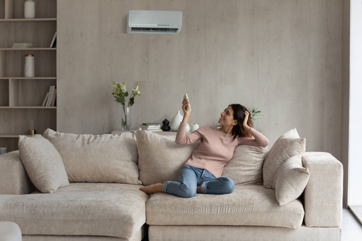 une propriétaire de maison visualisation un problème de clim et cherchant comment savoir si son système de climatisation a un problème pour appeler un pro
