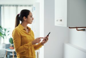 Femme qui règle la température d'une chaudière à gaz